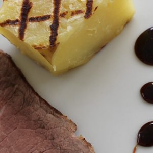 Photo of roast beef with fondant potato and balsamic reduction sauce