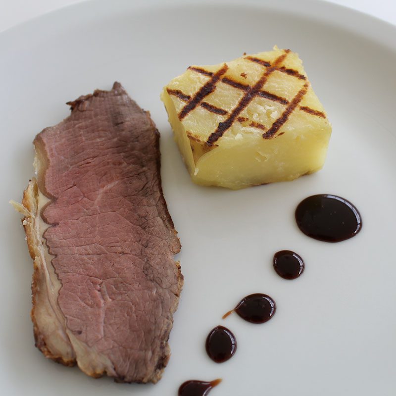 Photo of roast beef with fondant potato and balsamic reduction sauce