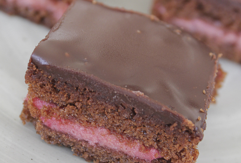 Bite sized layer cakes with chocolate and raspberry mousse.