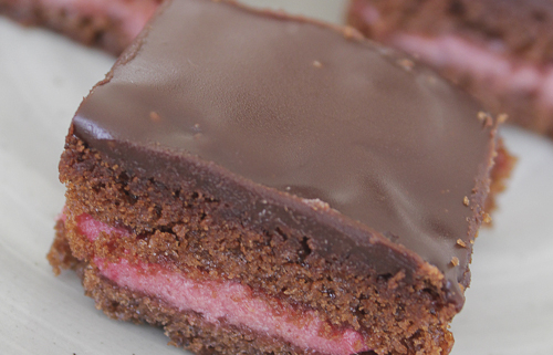 Bite sized layer cakes with chocolate and raspberry mousse.