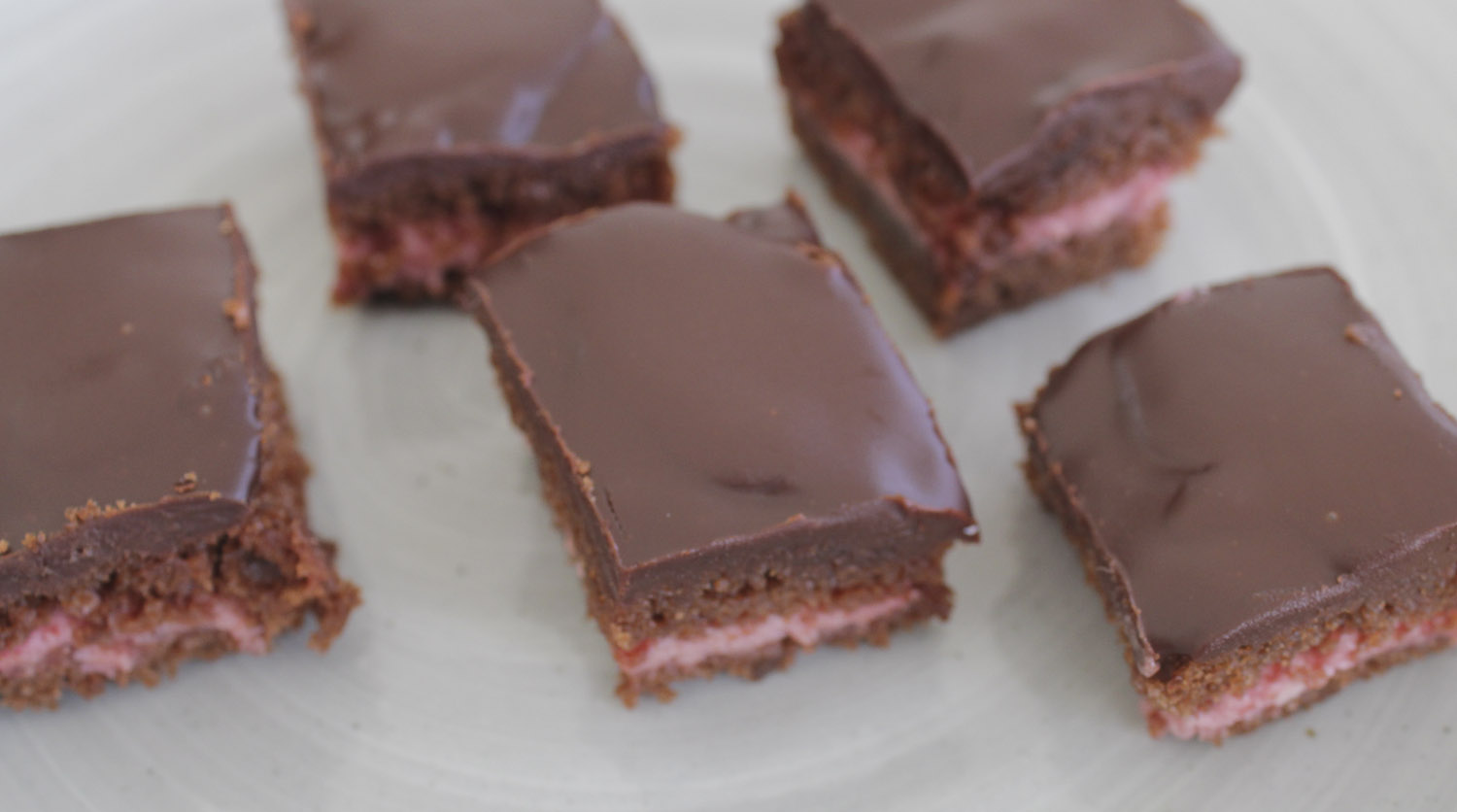 Bite sized layer cakes with chocolate and raspberry mousse.